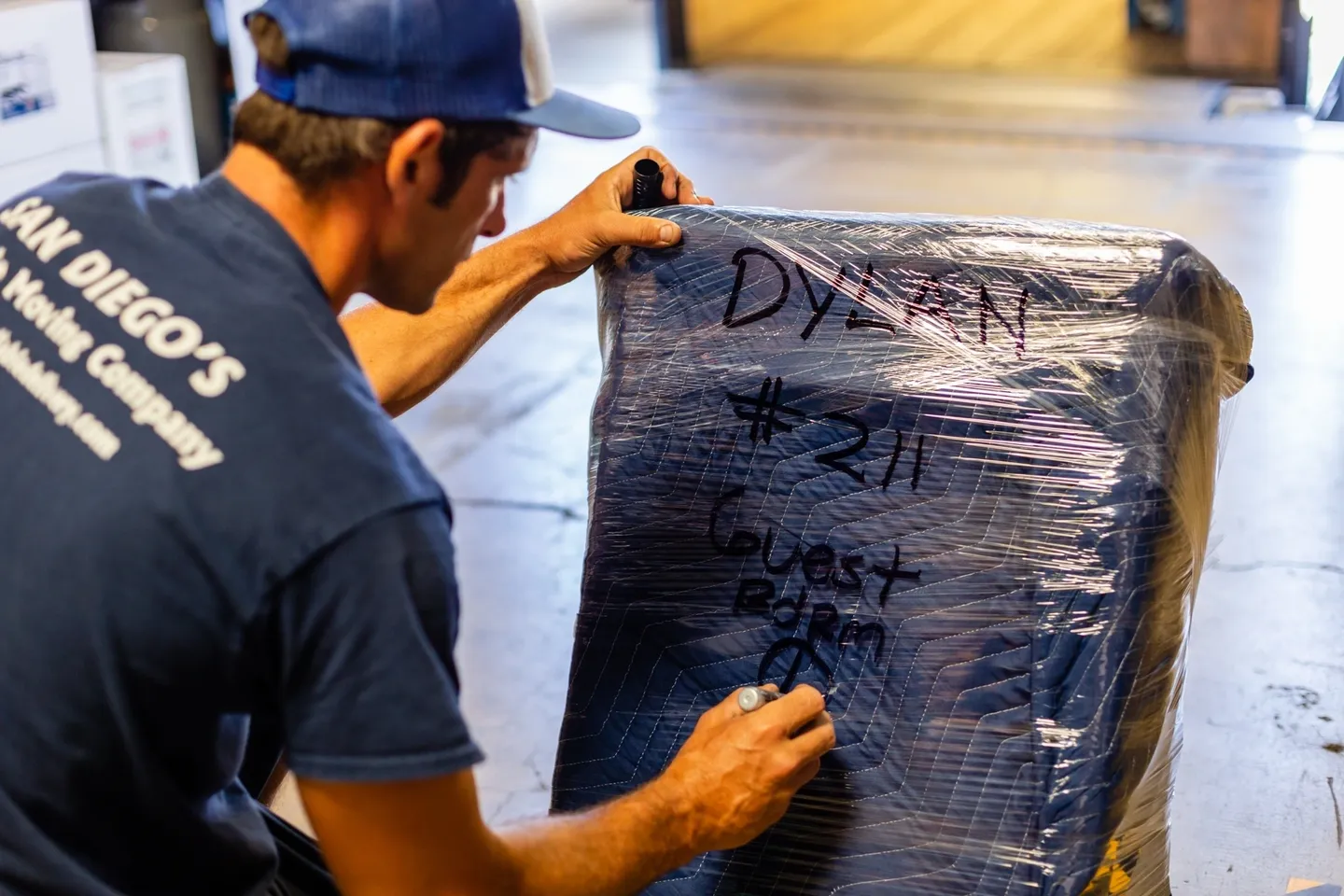 A man writing on the back of a box.