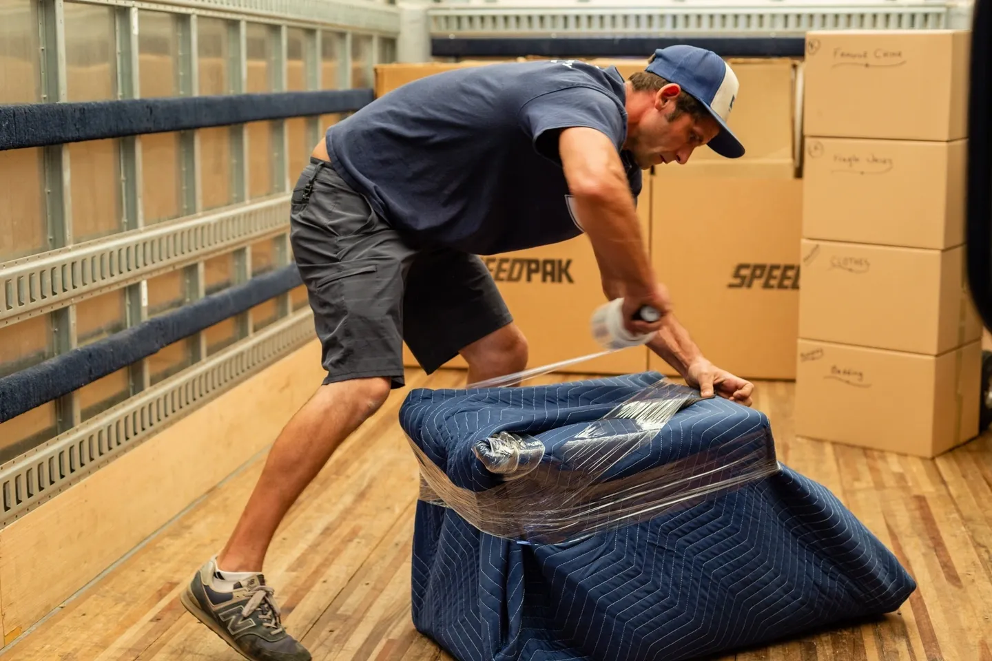 A man is moving boxes on the back of a truck.