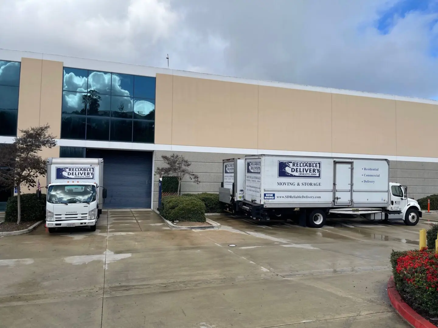 Delivery truck parked outside a commercial building with overcast skies.