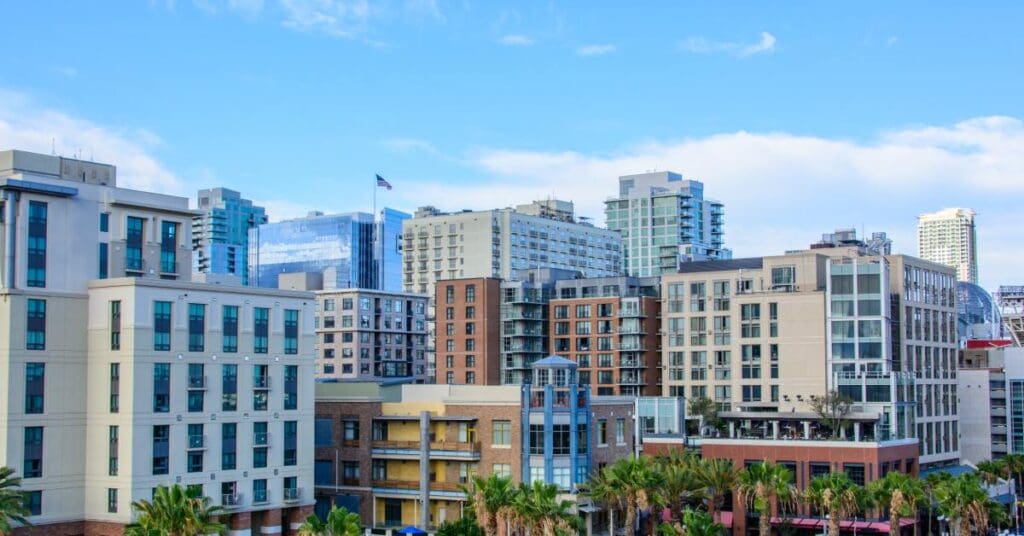 A cluster of apartment, condo, and commercial buildings in a Californian city on a sunny day.
