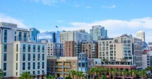 A cluster of apartment, condo, and commercial buildings in a Californian city on a sunny day.